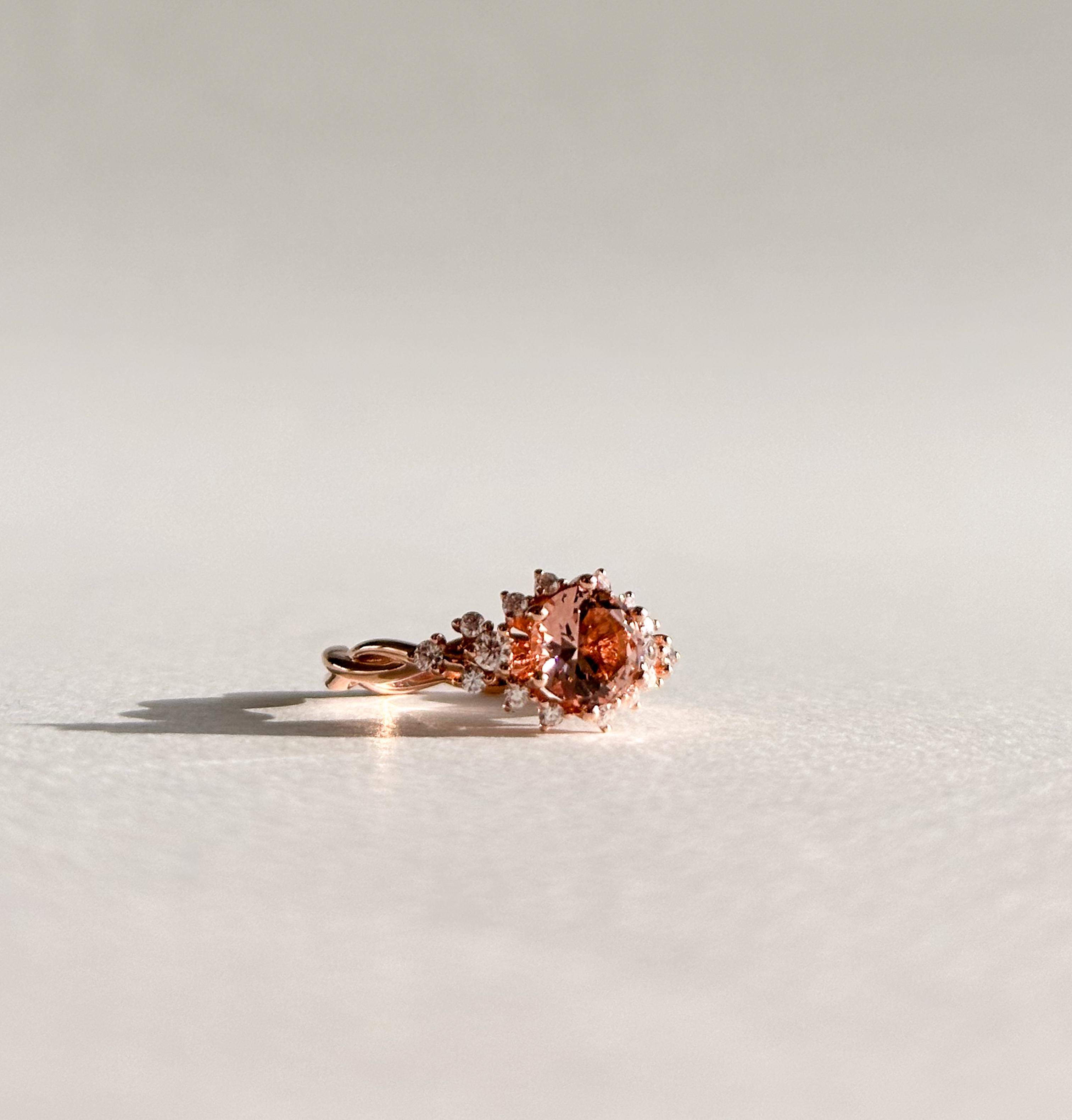 Round brilliant morganite featuring accenting diamonds on a twisted rose gold band
