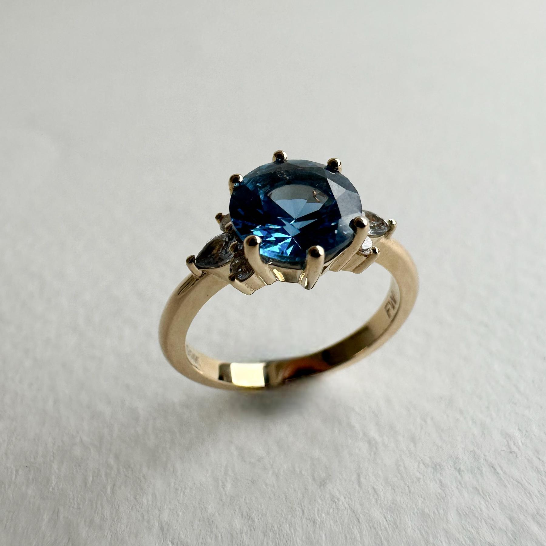 2 carat equivalent blue sapphire engagement ring featuring six accenting diamonds in a 14K yellow gold ring.