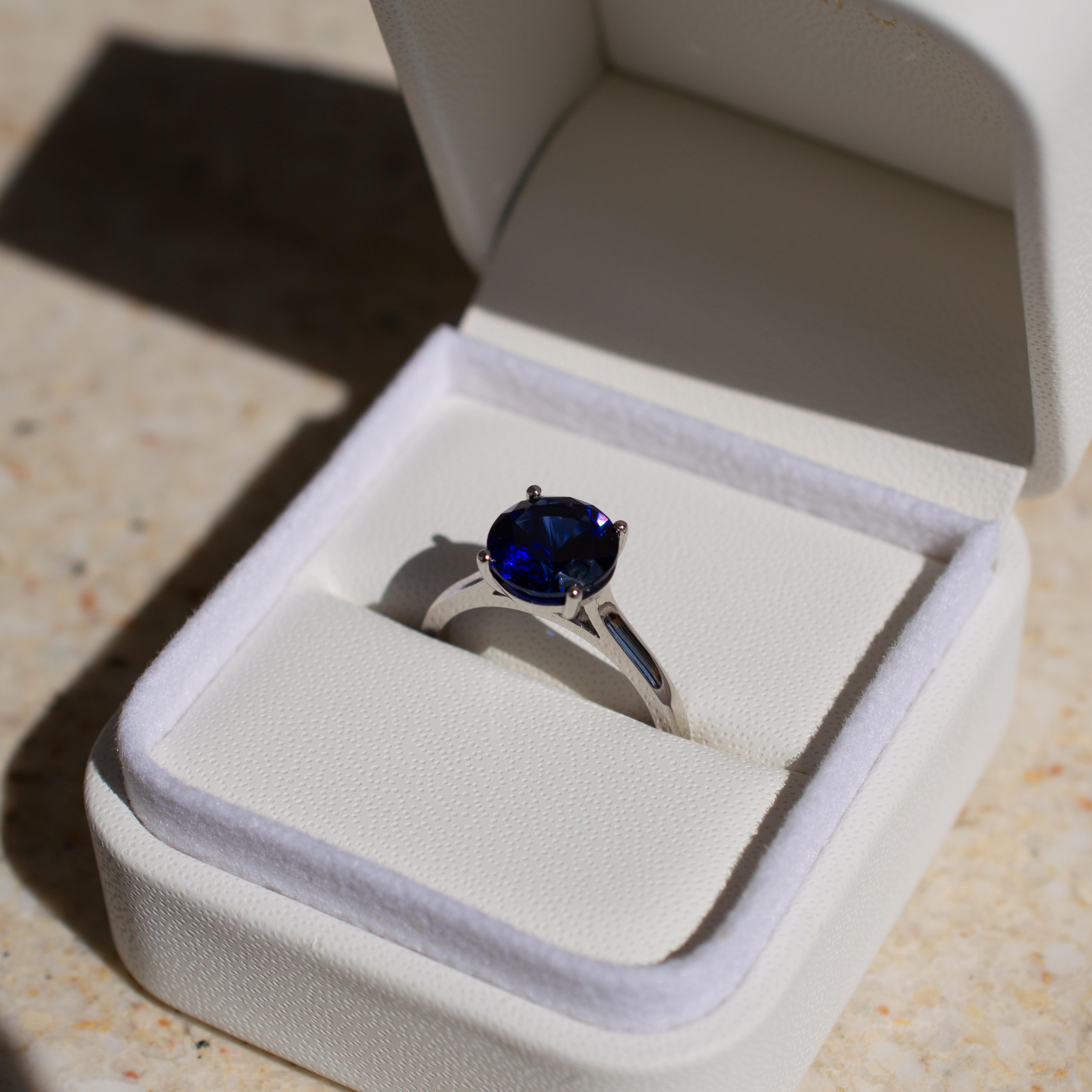1.5 carat round brilliant dark blue sapphire engagement ring in a platinum band
