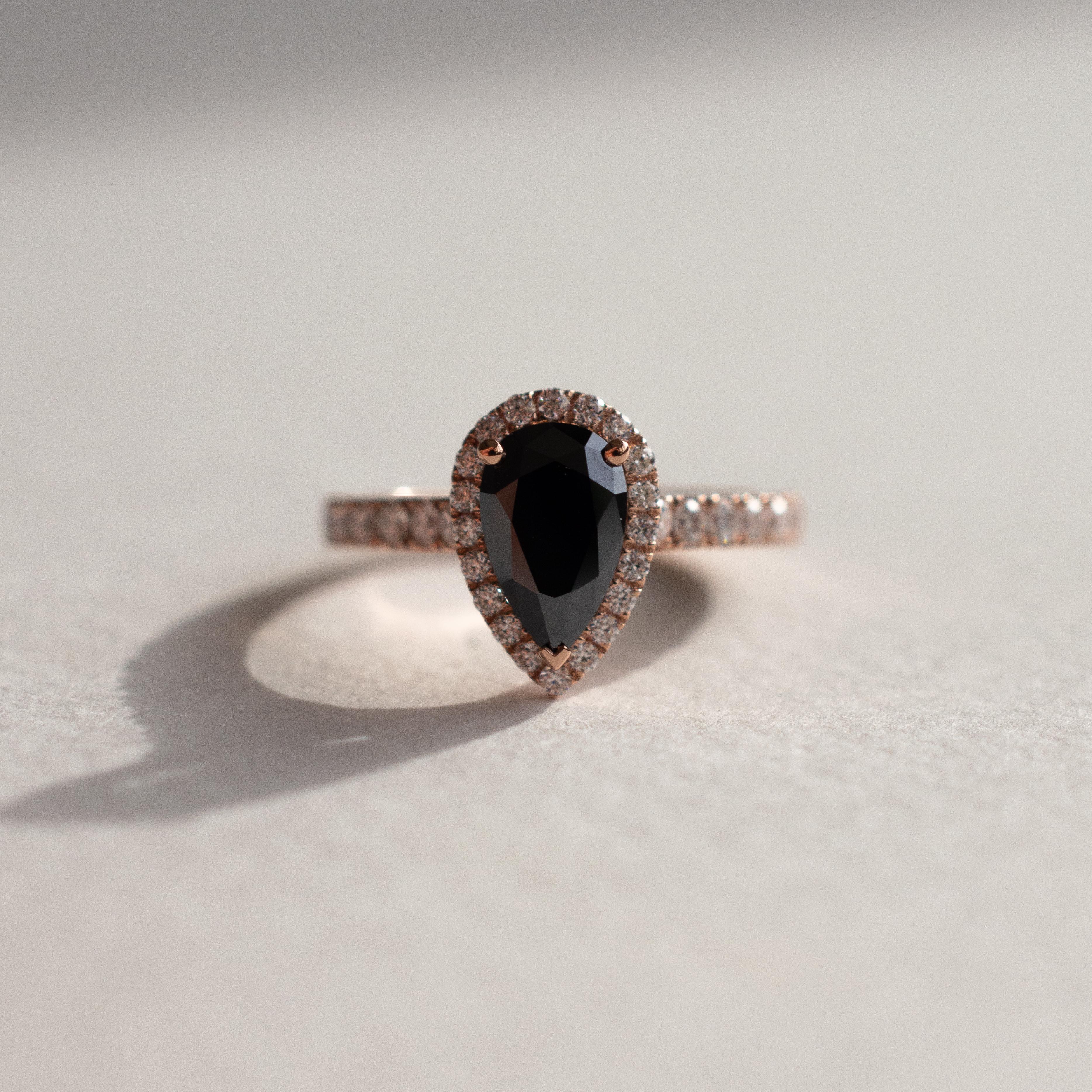 1.5 carat equivalent black moissanite in a yellow gold band with pave diamonds.
