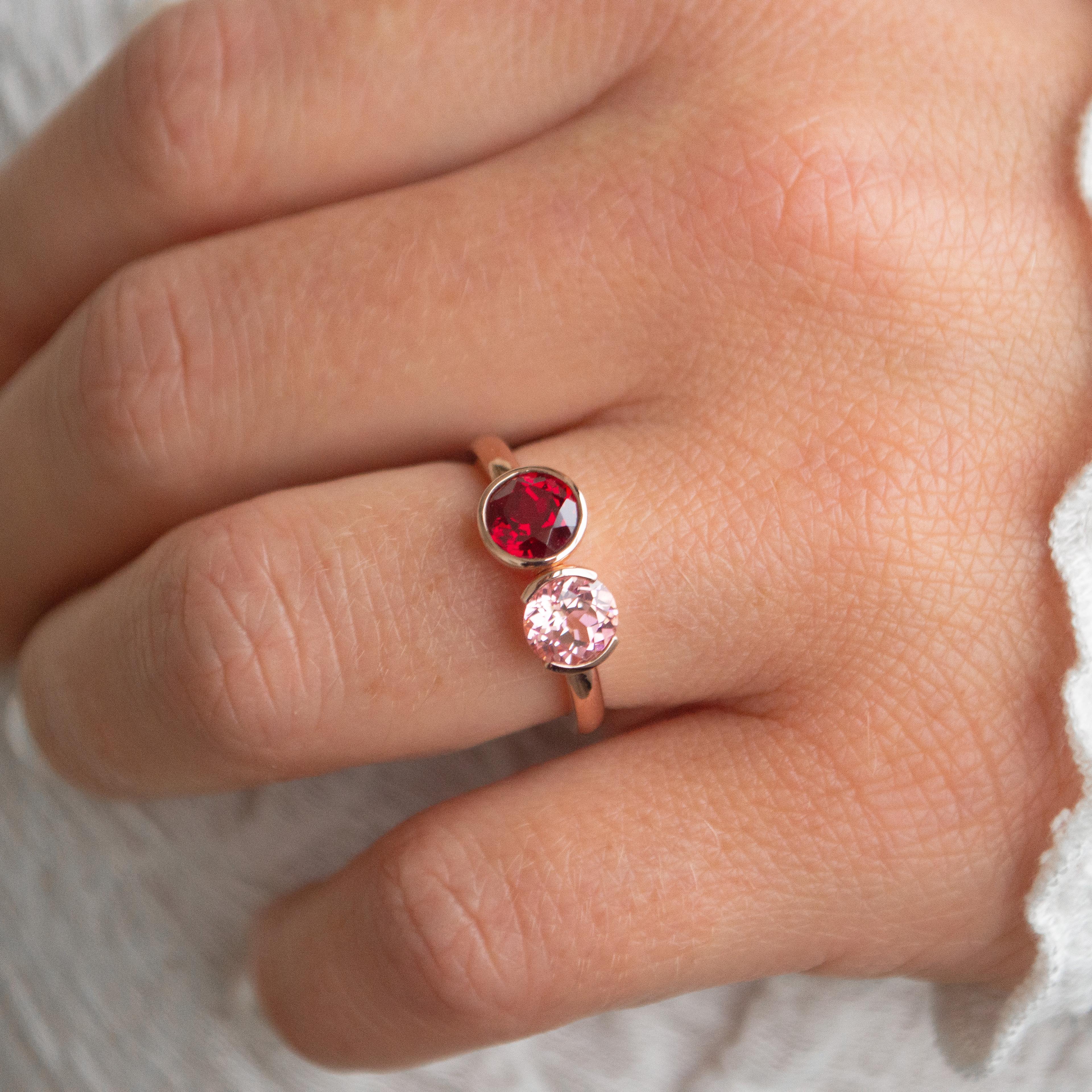 Toi et moi round cut ruby in full bezel and round cut pink sapphire in half bezel engagement ring in a yellow gold band.